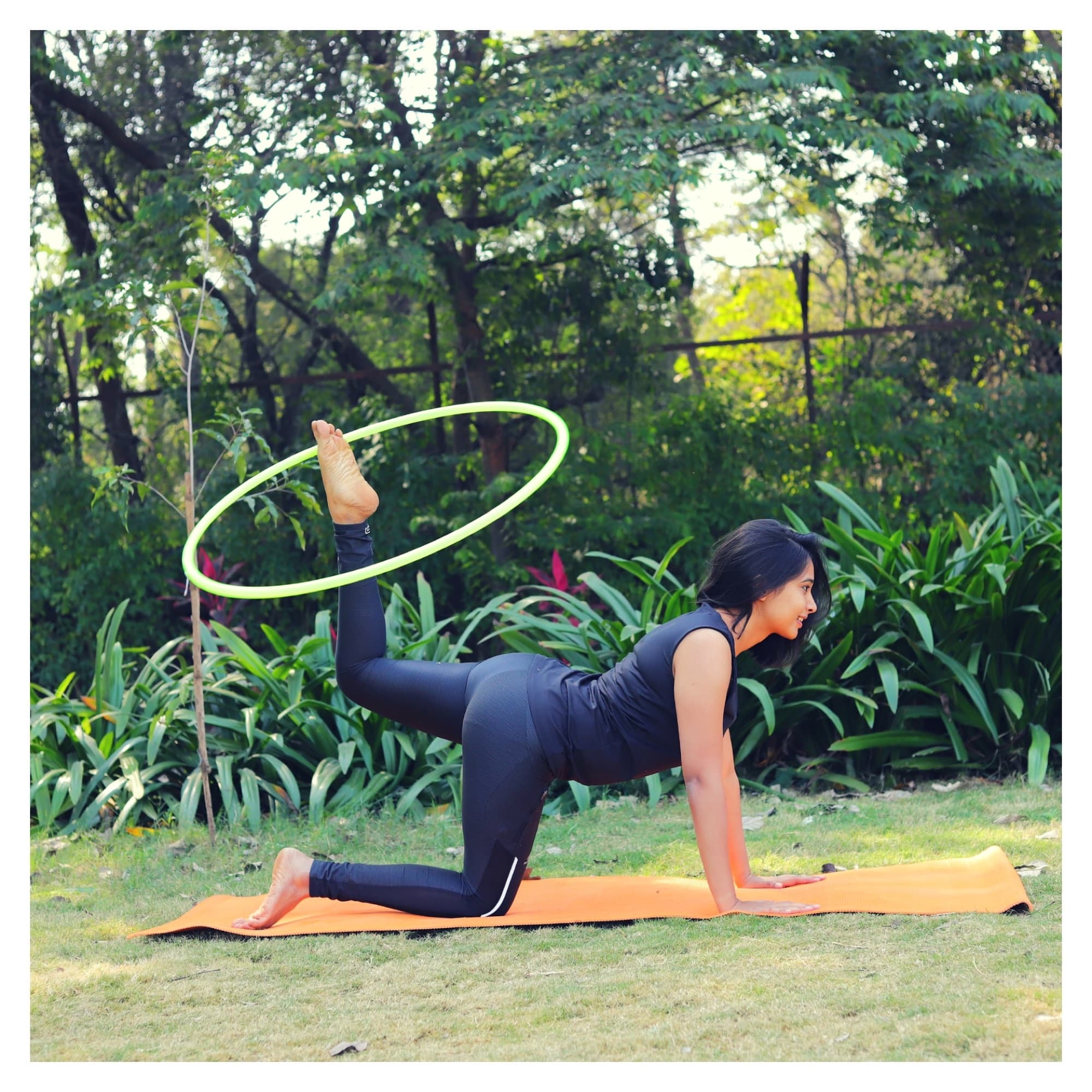 Devina in a table-top yoga pose with a hula hoop