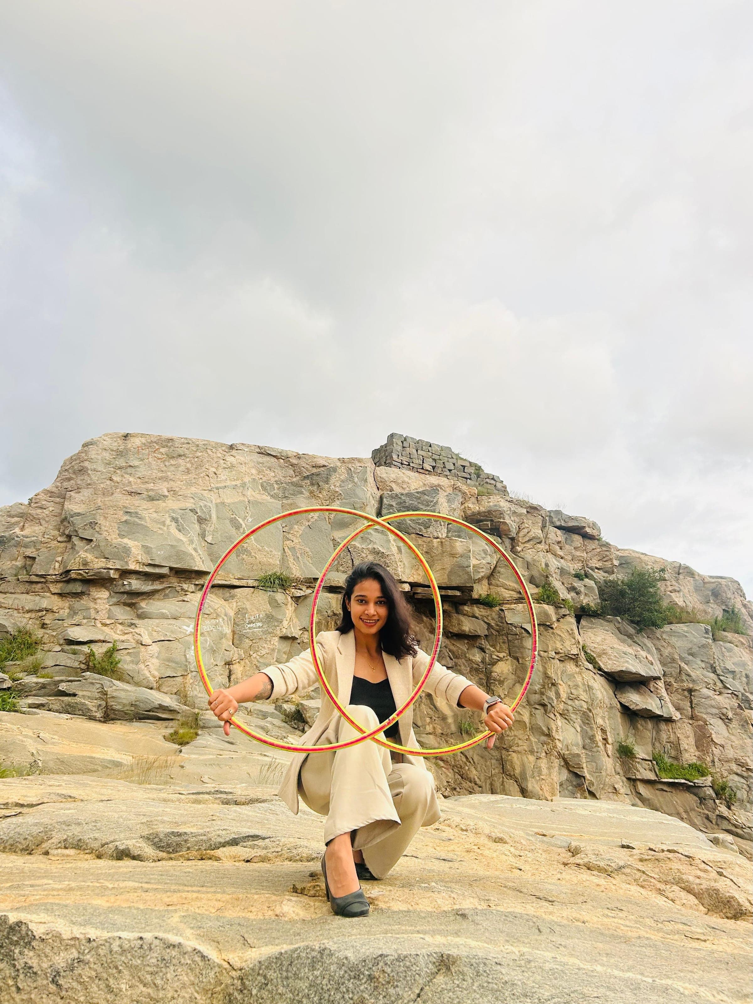 Devina hooping outdoors on a rocky hilltop